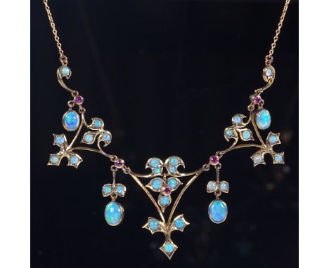 An Edwardian 9ct gold opal and ruby collar necklace, pierced floral settings with opal leaf drops, necklace length 42cm, 6.9g