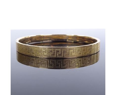 A 9ct gold slave bangle, with engine turned decoration, maker's marks MPG, band width 8mm, internal diameter 70mm, 11.7g 