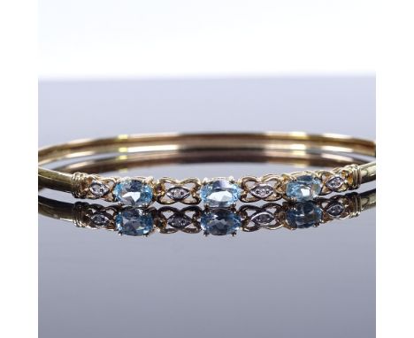 A 9ct gold blue topaz and diamond bangle, band width 4.4mm, internal diameter 62mm, internal height 53mm, 5g 