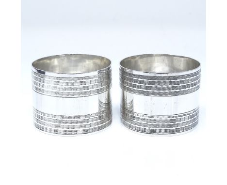 A pair of George V silver cylindrical napkin rings, with engine turned decoration, by E J Houlston, hallmarks Birmingham 1920