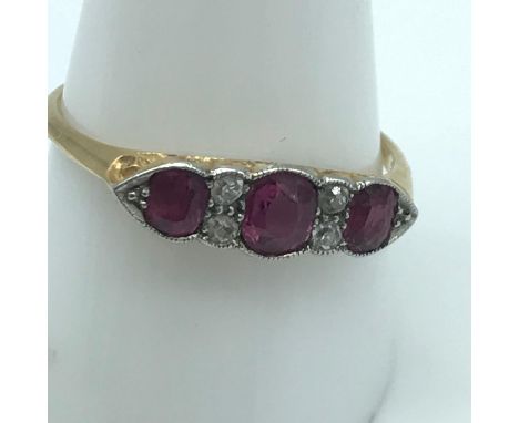 An 18ct gold ladies ring set with 3 Ruby stones and four diamonds. Ring size T. 