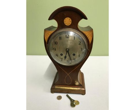 An Edwardian mantel clock in a working condition, Ornately designed, Inlaid and has a presentation plaque To M.DAVID COCKBURN