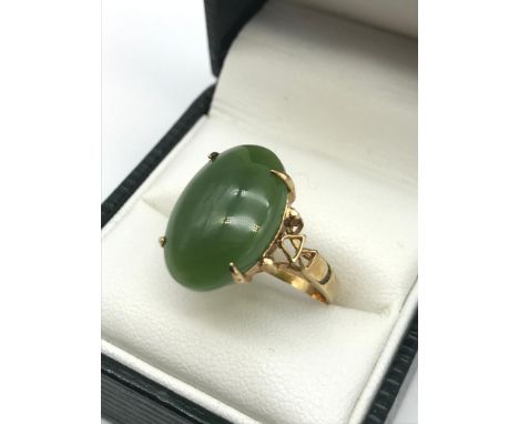 An antique gold ring set with a large oval shaped jade stone, Ring size J, Weighs 3.60 grams, Stone measures 1.8x1.2cm 