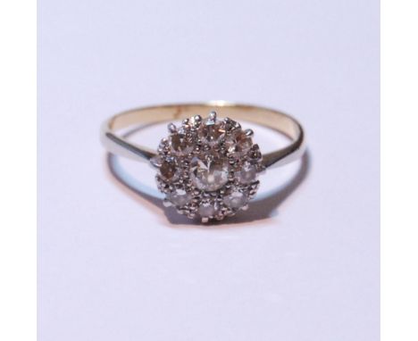 Diamond cluster ring set with a brilliant-cut stone measuring just under .5ct, surrounded by smaller diamonds measuring appro