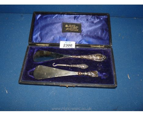 A presentation cased Silver handled shoe Horn and button Hook, Birmingham 1907, makers B &amp; Co. and another shoe Horn, par