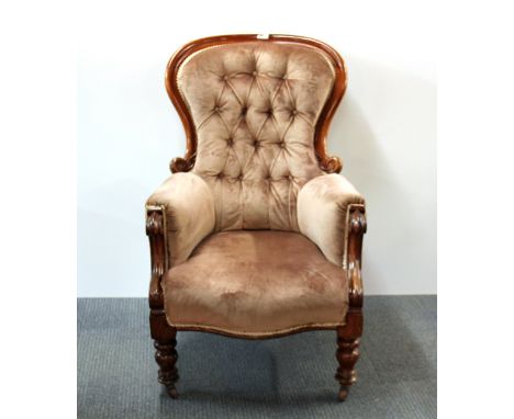 A mid 19th century mahogany button backed arm chair.