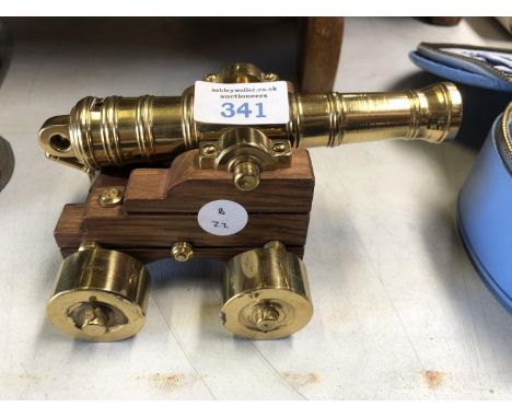A WOODEN AND BRASS SMALL MODEL OF A CANNON 