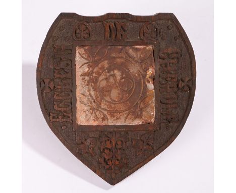 Medieval tile with quatrefoil pattern centre, mounted in an Arts and Crafts carved oak frame inscribed "Ecclesia de Cheadle",