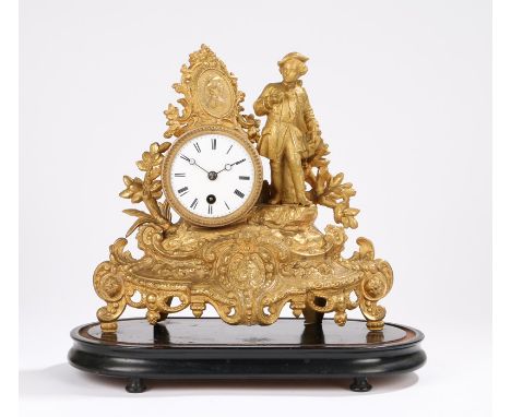 Late 19th Century French gilt spelter mantel clock, with a figure standing to the side of the drum case above a foliate scrol