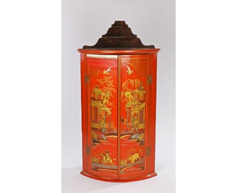 George III red lacquered hanging corner cupboard, the pediment with two shelves above the two bow front doors decorated with 