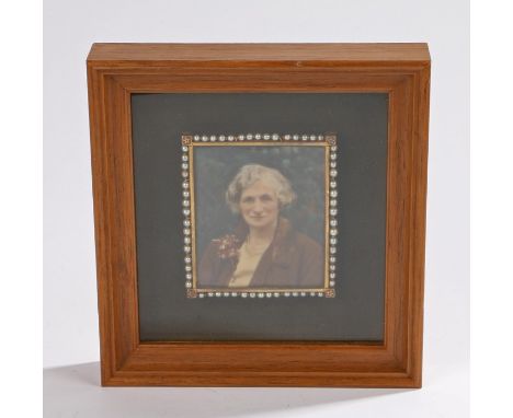 Early 20th Century portrait miniature, of a lady with a posy in her jacket, the frame with a row of pearls 7.5cm x 5cm, house