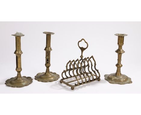 Victorian brass Gothic revival toast rack, a Georgian candlestick by Joseph Wood and two candlesticks with scallop bases and 