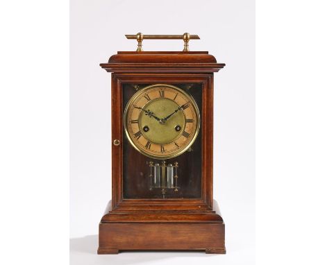 Early 20th Century walnut mantel clock, the gilt metal handle above a glazed door and sides, the dial with Roman hours to the