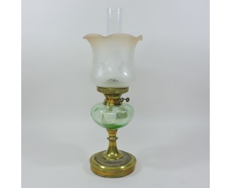 A Victorian brass oil lamp, with a green glass reservoir and an etched glass shade, 53cm tall overall
