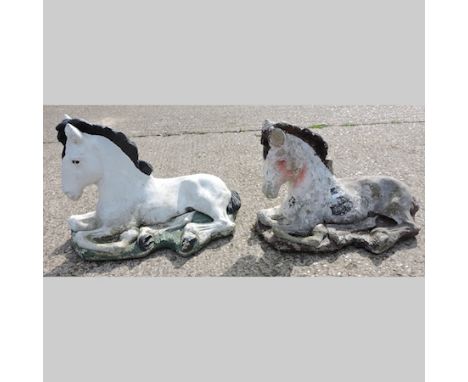 A reconstituted stone model of a reclining horse, 65cm, together with another similar