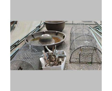 A cast iron circular pig trough, 61cm diameter, together with a cast iron circular bowl and a collection of traps