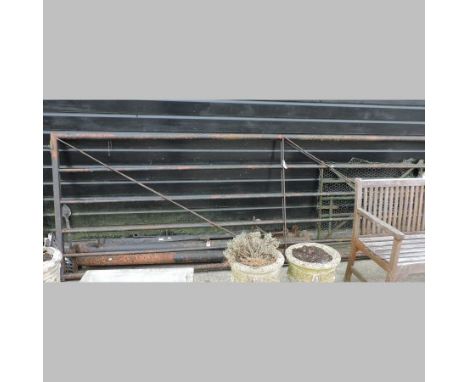 A black painted metal six bar stock gate, 378cm, together with three posts, a hand gate and large iron hinges etc