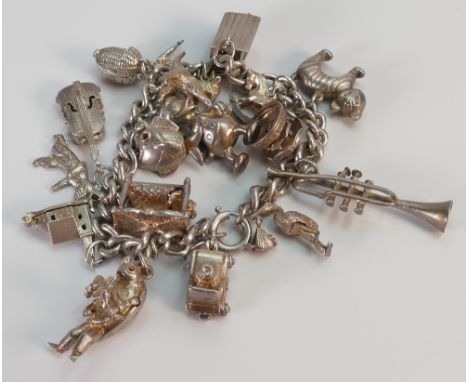 Silver charm bracelet with 18 charms, 70.9 grams.