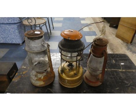 A Collection Two Hurricane Lamps and a Tilley Lamp 