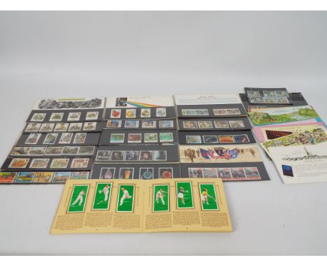 Philately - A small quantity of Royal Mail Mint Stamp presentation packs and a tennis players cigarette card album.