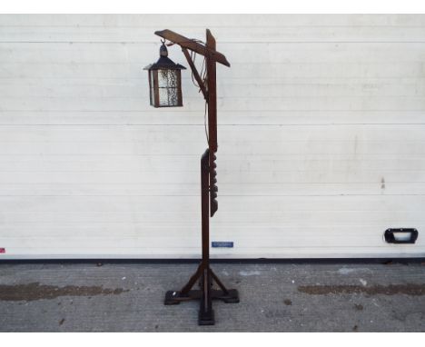 An adjustable, wooden standard lamp with lantern style light, approximately 165 cm when fully extended.