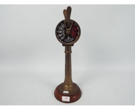 A brass model of a ships's engine room order telegraph. Approximately 40 cm (h). Minor crack to plastic of the telegraph. Mov
