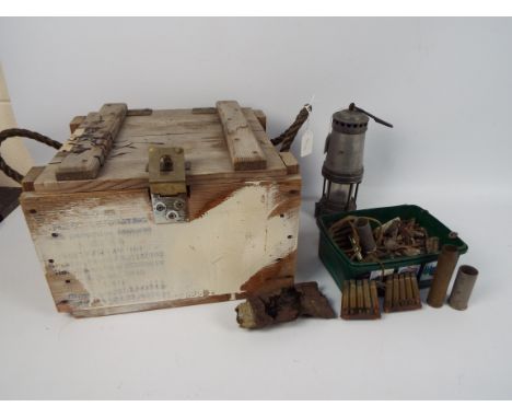 A safety type lamp, 25 cm (h), and an ammunition crate, 24 cm x 36 cm x 33 cm, containing a quantity of spent ammunition.