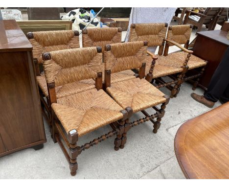 A SET OF SIX JACOBEAN STYLE OAK DIN ING CHAIRS WITH RUSH SEATS AND BOBBIN TURNED STRETCHER RAILS 