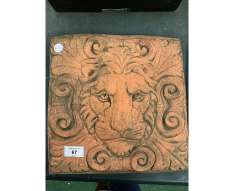 A TERRACOTTA LIONS HEAD WALL TILE 