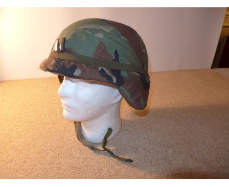 AN ARMY HELMET, WITH CAMOFLAGE COVER 