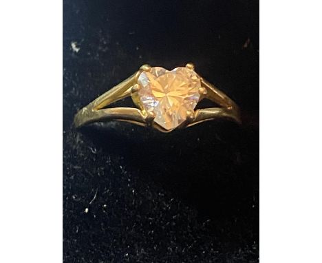 A 9 CARAT GOLD RING WITH A HEART SHAPED CLEAR STONE 