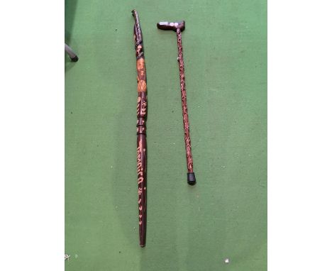 A CARVED WOODEN WALKING STICK FEATURING A CAT HANDLE AND A WOODEN SNAKE HANDLE WALKING STICK WITH ORNATE CARVING JAMAICA 