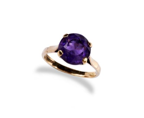 AN AMETHYST RING the single round mixed-cut amethyst with in a four claw setting, between tapered shoulders, and plain band  