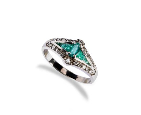 AN EMERALD AND DIAMOND DRESS RING, CIRCA 1900 the central oval emerald set above six channel set tapered baguette cut emerald