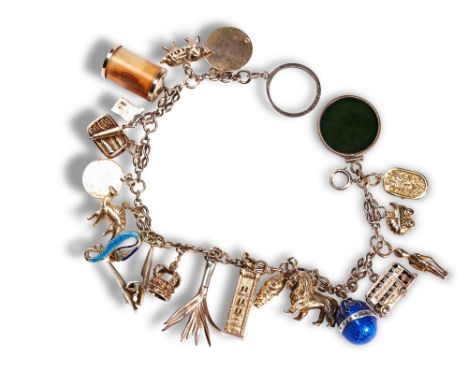 A 20TH CENTURY CHARM BRACELET 21 charms on a fancy link bracelet with bolt ring fastening. Charms include 10 shilling note in