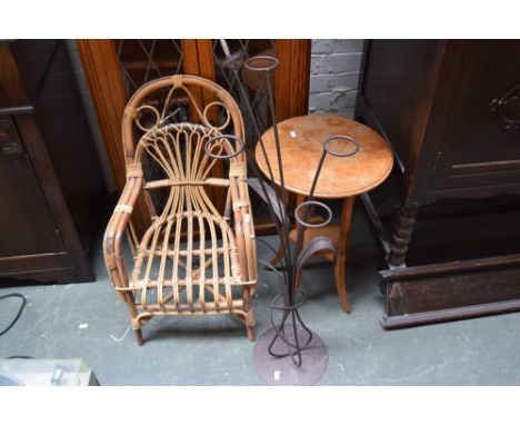 An oak table with under shelf and splayed legs, a child bamboo chair together with a metal garden in the style of reed