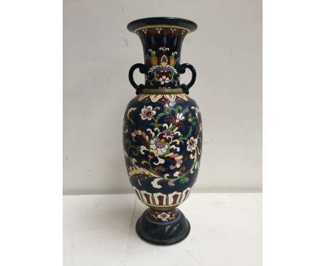 A ceramic vase with loops handles of colourful floral design over blue ground 40 cm