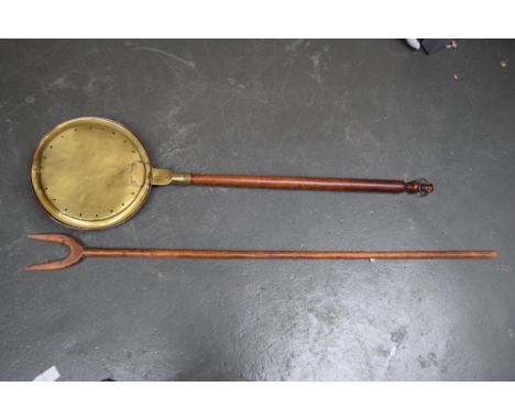A vintage wooden hay fork and a bed pan