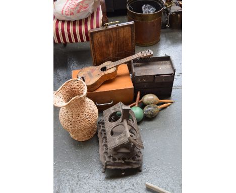 A mixed lot to include an unusual wooden bottle holder in the form of a house, a wicker jug, a banjo, two pairs of maraccas, 
