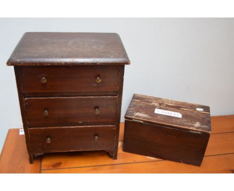 A small stained pine chest of drawers with three drawers together with a vintage box of wax candles