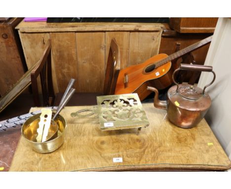A Victorian copper kettle, a brass trivet stand, two brass and iron handled saucepans, and a brass button polished 