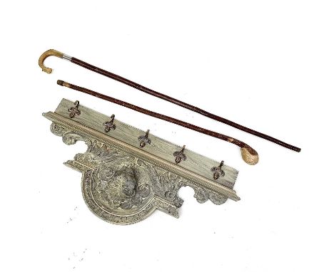 A painted oak coat rack with five brass hooks carved with a stylised animals head, a horn handled shepherds crook carved with