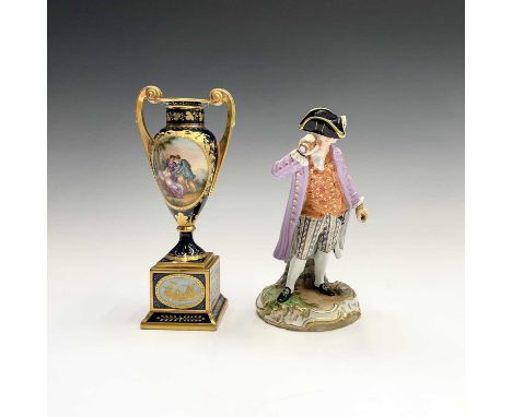 A Vienna porcelain urn, circa 1900, with twin handles and two painted panels within blue and gilt borders, on a pedestal base