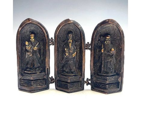 An Eastern bronze triptych portable shrine, hinged to reveal three Deities, height 14cm.