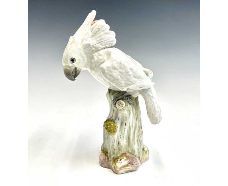 A Meissen porcelain figure of a cockatoo, mid 19th century, with lightly detailed plumage and perched on a tree trunk, crosse