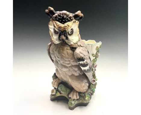 A French porcelain figure of an owl, late 19th century, with inset eyes and painted detail, with a flower encrusted small vas