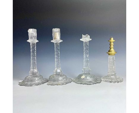A suite of three Georgian cut glass candlesticks, with multi-facetted stems, height 28cm, together with a cut glass lamp base