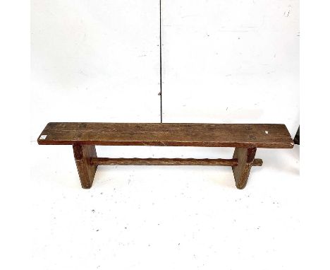 A pine bench circa 1900, with solid shaped end supports, united by a stretcher, width 178cm.