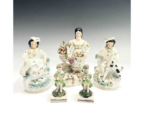 A pair of Staffordshire Pearlware figures of putti holding baskets of flowers, height 10cm, together with a pair of Staffords