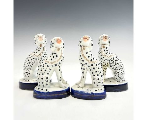 A pair of Victorian Staffordshire figures of seated dalmatians, with gilt chains, on blue bases, height 13cm, together with a